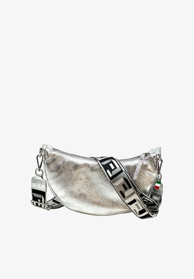 Metalen zilveren handtas met een gebogen vorm, voorzien van een gestreepte zwart-witte schouderband en een klein vlaggenhangerdetail. Ritssluiting.