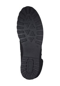 Semelle de botte en caoutchouc noir avec un motif de semelle rugged, comportant des formes surélevées et des détails de marque. Conçue pour l'adhérence et la durabilité.