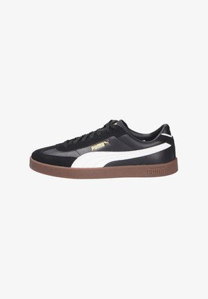 Svart sneakers med hvite detaljer og gull logo. Laget av skinn og semsket skinn, med rund tå og en brun gummisåle. Klassisk lavt design.