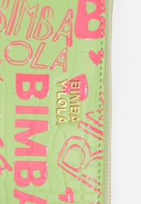 Zielony, błyszczący materiał z wytłoczonym różowym napisem "BIMBA Y LOLA" i wzorami w kształcie serc. Złote detale logo przy suwaku. Gładka struktura.