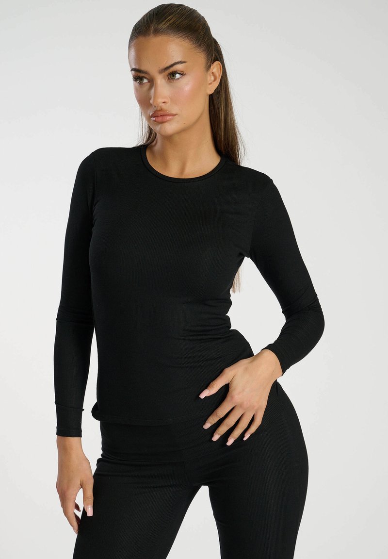 Czarny, długi rękaw, prążkowany top z okrągłym dekoltem, dopasowany krój i miękka faktura, w połączeniu z pasującymi, wysokimi spodniami.