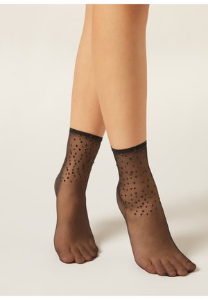 Schwarze transparente Knöchelsocken mit einem strukturierten Muster aus kleinen schwarzen Perlen, abgeschlossen mit einem gerippten schwarzen Bündchen oben.