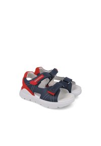 Sandalias azul marino con acentos rojos, hechas de material sintético. Presentan dos correas de Velcro ajustables y una suela de goma blanca.