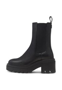 Botín negro hasta el tobillo con una plataforma gruesa, material de cuero suave, paneles elásticos en los costados y una lengüeta en la parte trasera. Suela texturizada para proporcionar agarre.