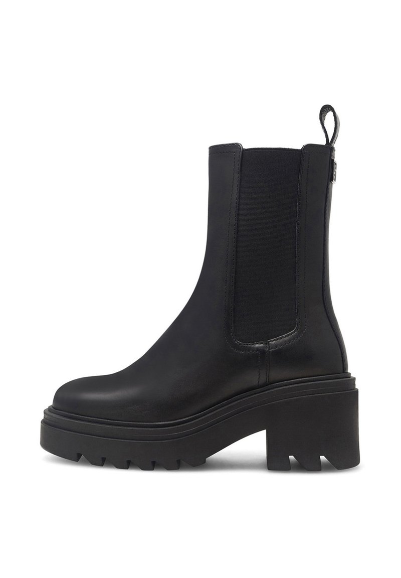 Botín negro hasta el tobillo con una plataforma gruesa, material de cuero suave, paneles elásticos en los costados y una lengüeta en la parte trasera. Suela texturizada para proporcionar agarre.