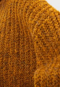 Gestrickter Pullover in einem satten goldorange-Farbton mit strukturiertem Rippmuster und weichem Garn, das sein gemütliches und warmes Aussehen betont.