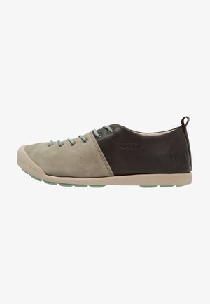 Light brown and dark brown leather shoe with mint green accents, round toe, flat rubber sole, and five lace eyelets on the front.