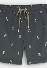 Pantaloni scurți de baie gri dintr-un material ușor, cu un model repetat de craniu și oase încrucișate. Finalizați cu un braț de ajustare la talie.
