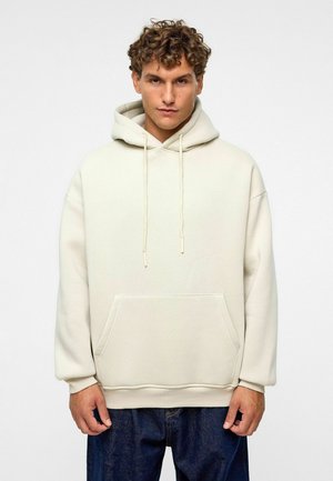Crème-kleurige hoodie, gemaakt van een zachte katoenmix, heeft een voorzak, verstelbare koordjes en ribgebreide manchetten. Ontworpen in een relaxed fit.