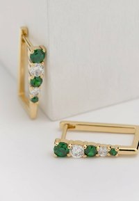 Orecchini rettangolari in oro caratterizzati da tre gemme tondi verde e due trasparenti, con finitura metallica lucida e montature a griffe.