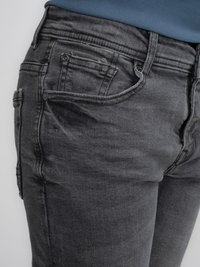 Jeans de mezclilla gris con un ajuste slim, bolsillos frontales y sutiles detalles de desgaste. Diseñados con un estilo clásico de cinco bolsillos y trabillas para cinturón.