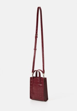 Small burgundy handbag with a crocodile embossed pattern, two short handles, and a long adjustable strap. Smooth texture.