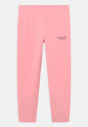 Pantalones jogger ajustados de color rosa con cintura y puños elásticos, con un pequeño logo negro "Calvin Klein Jeans New York" en el muslo superior.