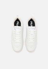 Sneakers atletici bianchi con tomaia in pelle liscia, punta rotonda e dettagli perforati. Suole interne nere con accenti di logo bianchi.