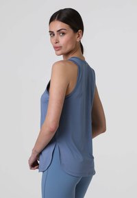 Canotta atletica senza maniche blu con orlo arrotondato, realizzata in tessuto leggero, dotata di uno spacco laterale per un comfort e una libertà di movimento ottimali.