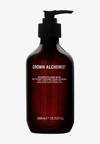 Bouteille en verre ambre avec un capuchon texturé noir. L'étiquette indique "Grown Alchemist Invigorate Hand Wash" avec les ingrédients en texte blanc.
