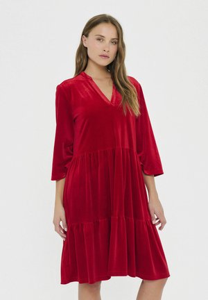 Rotes Samtkleid mit V-Ausschnitt und 3/4-Ärmeln, mit einem gestuften Rock und weicher Textur. Glatte Verarbeitung mit fließender Silhouette.