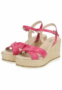 Sandali con tacco a cuneo rosa con cinturini incrociati in pelle e una piattaforma in juta tessuta e texture. Le suole sono bianche e presentano un battistrada per una migliore aderenza.