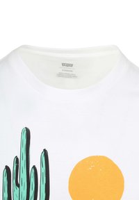 Camiseta de algodón blanca con un gráfico de cacto verde y un gráfico de sol amarillo. Cuello redondo y corte estándar. Textura suave.