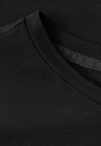 Black cotton t-shirt with a round neckline and smooth texture. Features a contrasting inner neck tape for added detail.