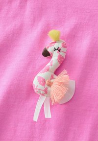 Flamingo formos pleistras su rožiniu gėlių raštu, tekstūruotu kūnu, geltonu kuokšteliu ir rožinėmis kutais, ant rožinio fono.