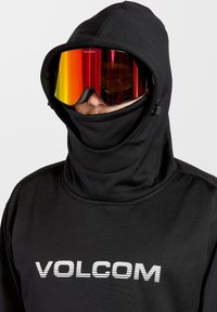 Black hooded sweatshirt with a high collar featuring a white logo. Paired with reflective red ski goggles, enhancing visibility and protection.