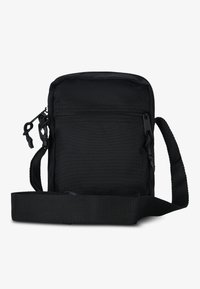 Borsa a tracolla nera in tessuto con tasca anteriore con zip, tracolla regolabile e superficie testurizzata. Forma rettangolare compatta.