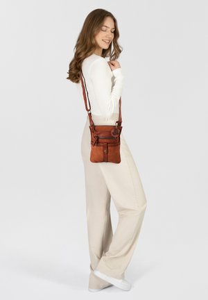 Borsa a tracolla in pelle marrone con molteplici tasche con zip, texture liscia, tracolla regolabile e dettaglio circolare in metallo.