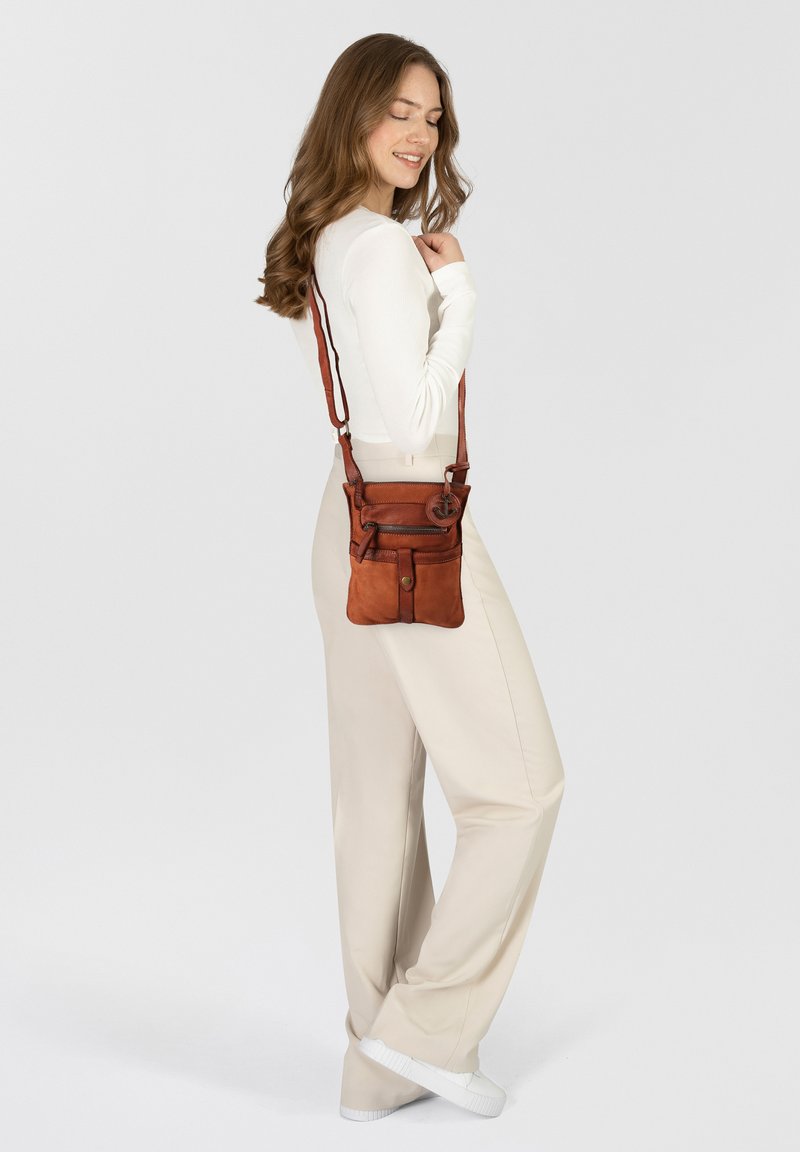 Borsa a tracolla in pelle marrone con molteplici tasche con zip, texture liscia, tracolla regolabile e dettaglio circolare in metallo.