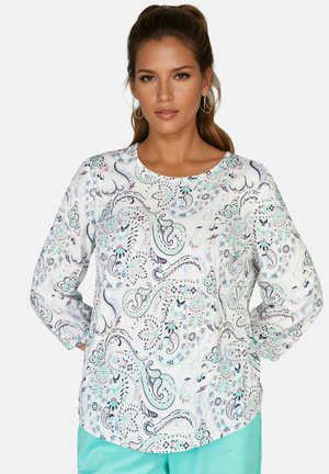 Langärmeliges Hemd aus weißem Stoff mit buntem Paisley-Muster und floralen Akzenten. Glatte Textur und runder Ausschnitt.