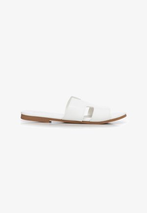 Sandalia blanca plana con doble tira ancha y puntera abierta, con un pequeño recorte rectangular y suela marrón.
