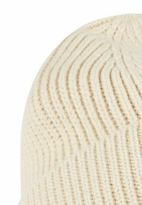 Knit cream beanie featuring ribbed texture and diagonal stripe pattern, designed to fit snugly, crafted from soft, warm material.