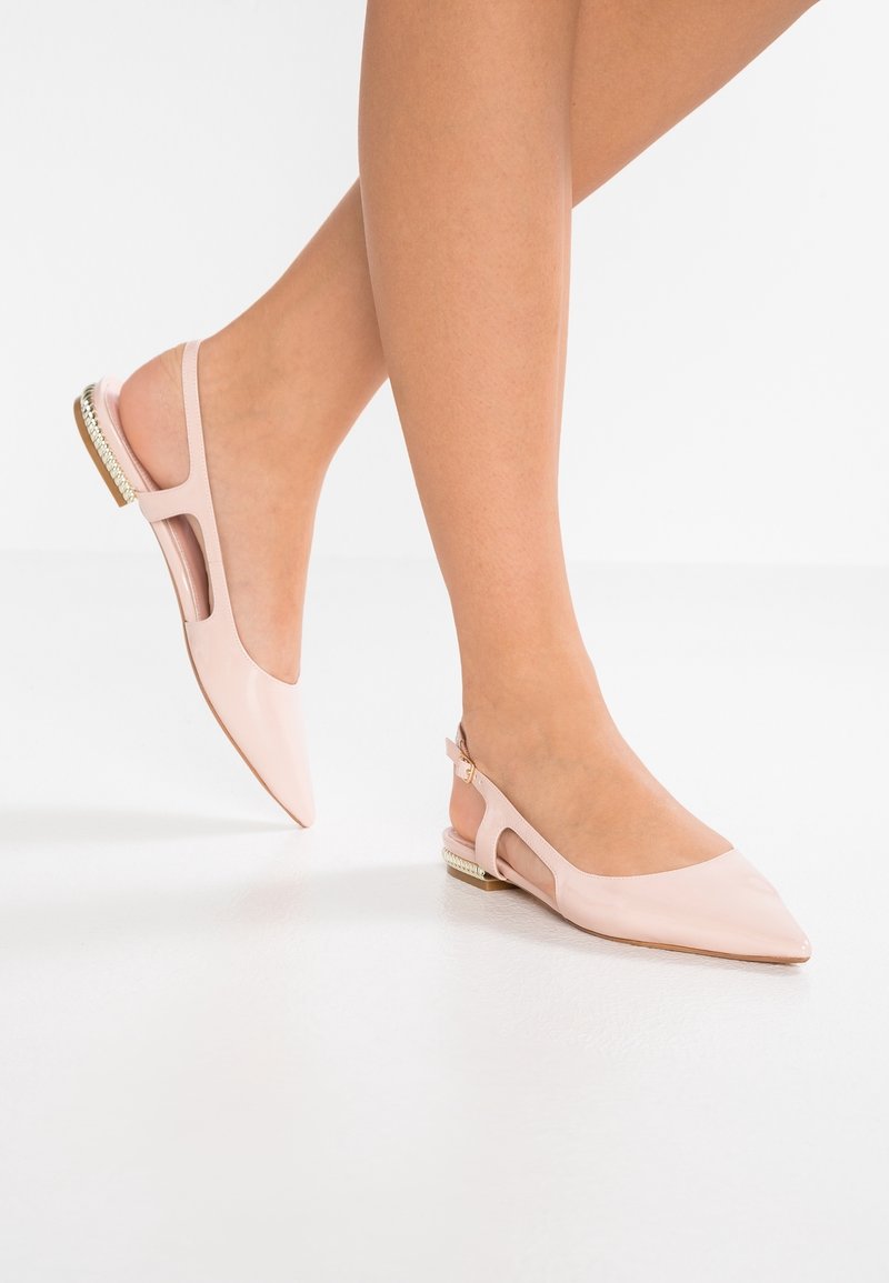 Růžové lakované slingback boty s špičatou špičkou, vyřezávaným bočním detailem a malým, zdobeným podpatkem. Hladká textura, minimalistický design.