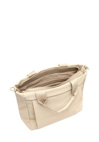 Beige tygväska med en slät, matt yta, som har dubbla handtag och en dragkedjestängning. Inuti finns flera fack för organisering.