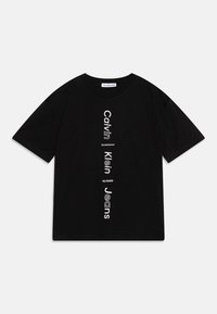 Černé bavlněné tričko s vertikálním bílým textem: "Calvin Klein Established" a "Jeans" spolu s číselným detailem. Kroužkový výstřih a krátké rukávy.