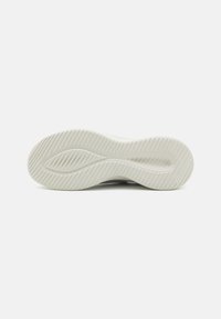 Suola di sneaker bianca in gomma con un motivo di battistrada ondulato e scanalature sottili per una migliore trazione. Design minimalista con una texture liscia.