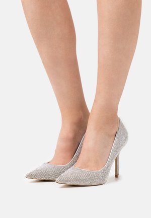 Zapatos de tacón alto plateados con punta afilada, cubiertos de brillantes rhinestones. Diseño elegante con una textura suave y un delgado tacón de aguja.