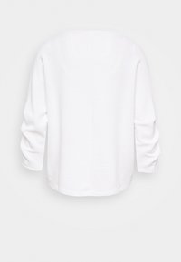 Vit lös passande topp med subtila horisontella ränder, långa ärmar, rund halsringning och rak nederkant.