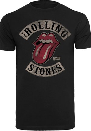 Schwarzes Baumwoll-T-Shirt mit einem abgenutzten roten Zungenlogo, darüber und darunter der Text "The Rolling Stones" in einer Vintage-Schriftart.