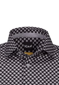 Camicetta nera con un motivo a conchiglia bianca ripetuto, colletto a bottoni e una consistenza liscia. Etichetta con la dicitura "Kauf, Modern Fit."