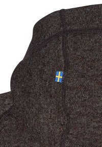 Brun strikket sweater med høj krave og struktureret finish. Har et lille svensk flag mærke nær sømmen.