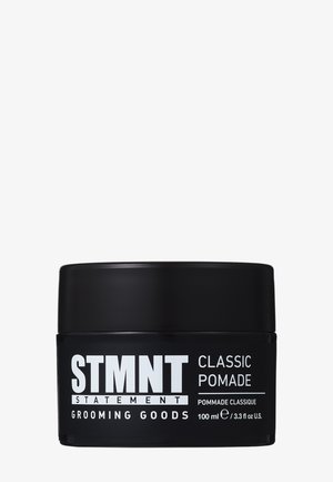 Contenant rond noir à finition mate. L'étiquette présente un texte blanc en gras. Contient 100 ml de pommade classique pour le toilettage.