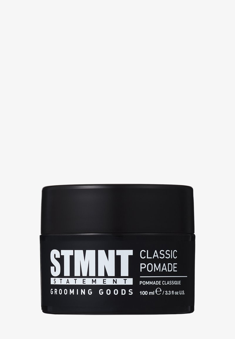 Zwart rond bakje met een matte afwerking. Het etiket bevat dikke witte tekst. Bevat 100 ml klassieke pommade voor verzorging.