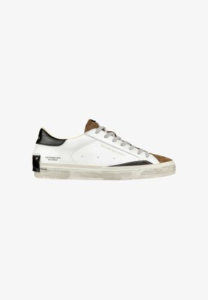 Sneaker bianca in pelle con dettagli in suede marrone, tallone nero, lacci grigi e suola invecchiata. Presenta del testo stampato sul lato. Design con punta arrotondata.