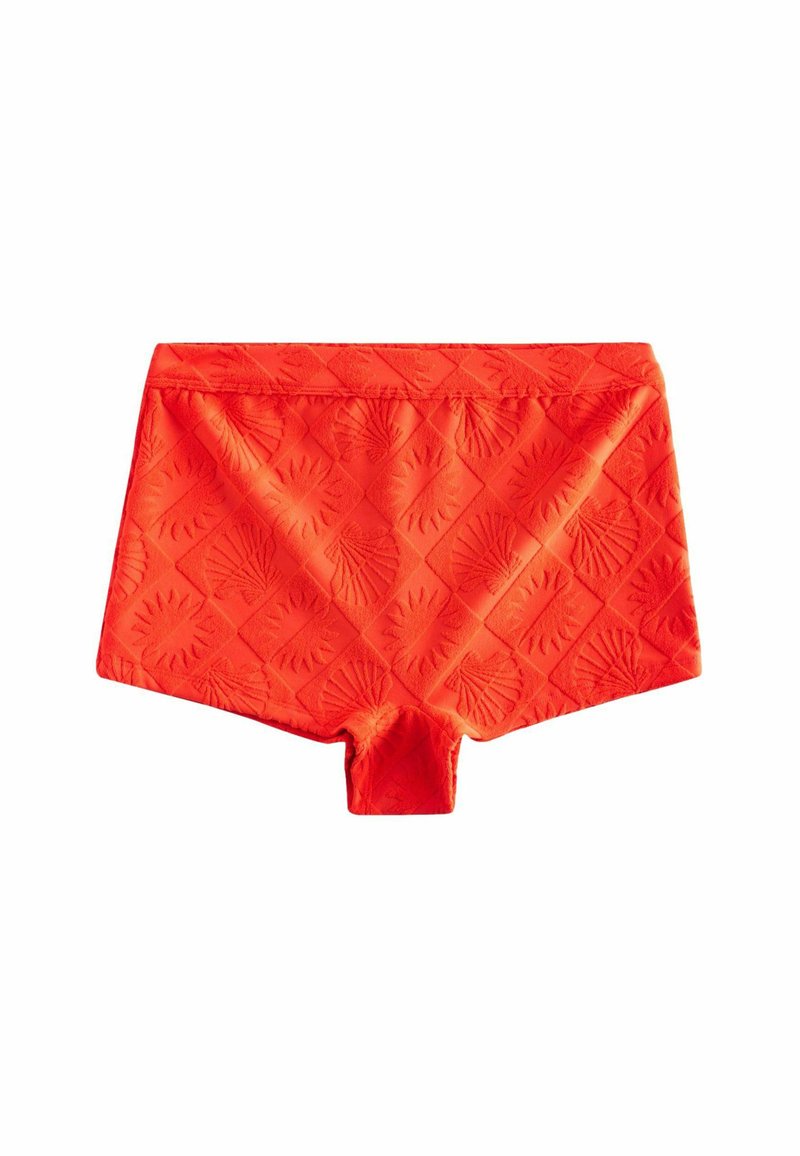 Shorts de bain rouges avec un motif en relief, forme rectangulaire, ceinture élastique et longueur mi-cuisse, fabriqués en tissu lisse.