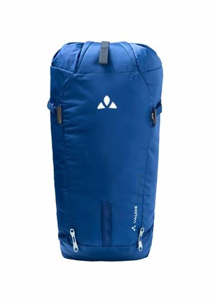 Zaino blu con forma cilindrica, realizzato in tessuto duraturo. Presenta una maniglia superiore, tasche laterali con zip e un logo in evidenza.