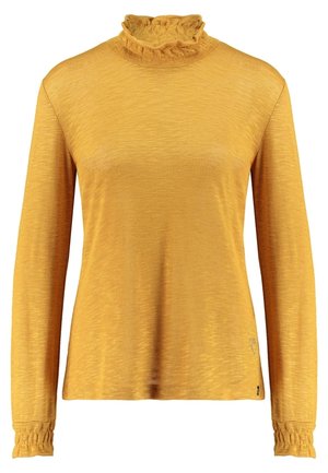 Sennepsgul langærmet damebluse med flæset høj hals og manchetter, lavet af blødt tekstureret stof.