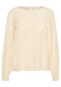 Lys beige bluse med et chevronmønster, lange ærmer, rund halsudskæring og let samling ved manchetterne. Lukning med nøglehul på ryggen.