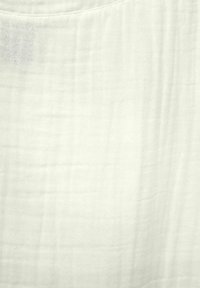 Tessuto leggermente testurizzato, bianco sporco, con un aspetto morbido e sgualcito. Presenta sottili variazioni di colore e motivo per una maggiore profondità.