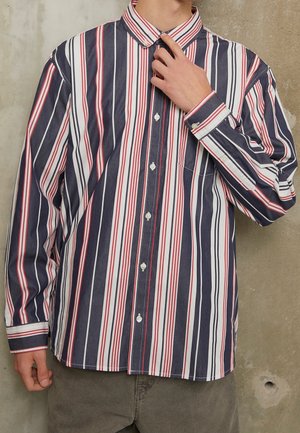 Gestreepte button-up shirt met verticale strepen in marineblauw, rood en wit. Lange mouwen, klassieke kraag, borstzak en knopen.